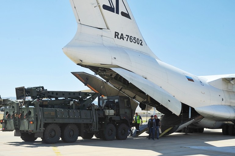 Military officials work around a Russian transport aircraft, carrying parts of the S-400 air defense systems, after it landed at Murted military airport outside Ankara, Turkey, Tuesday, Aug. 27, 2019.