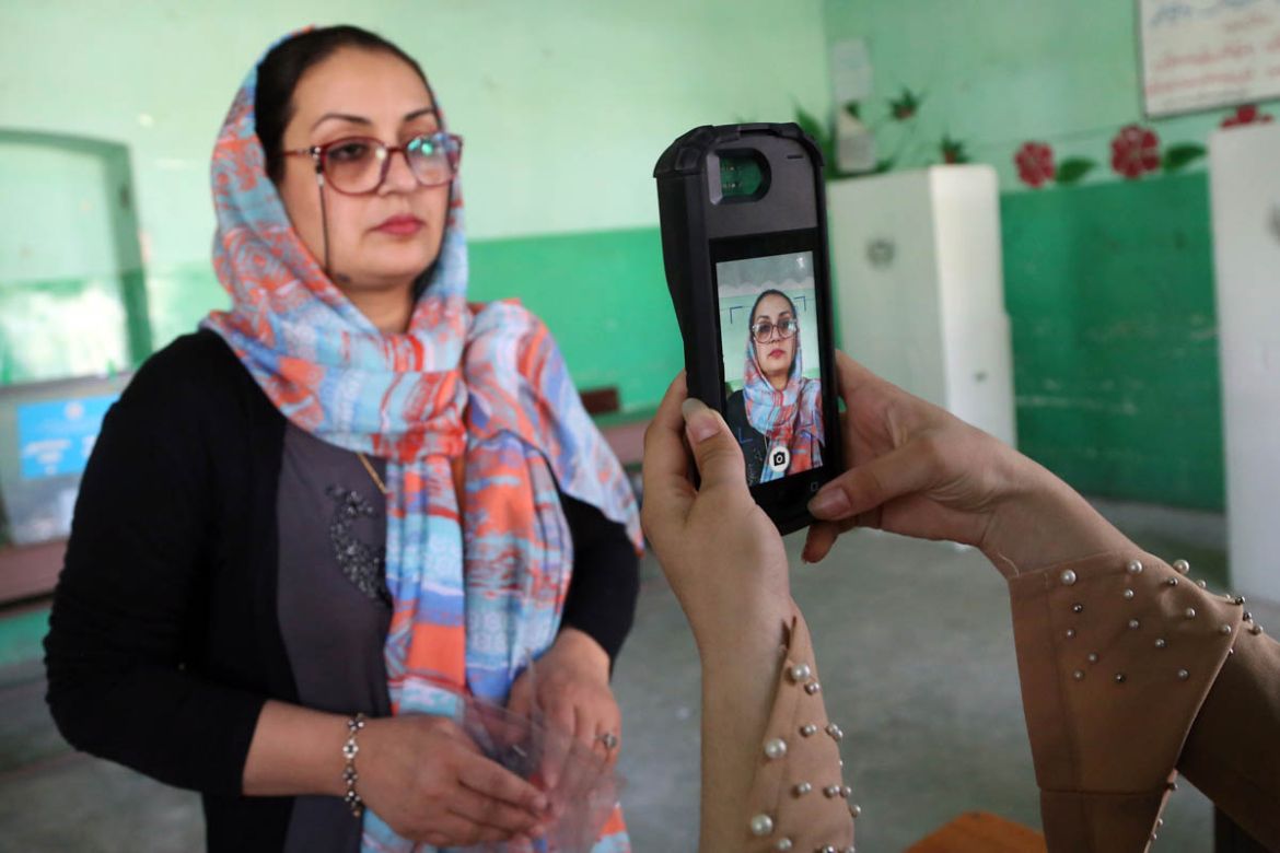 An Afghan woman poses for a picture, taken by an election official, before casting her vote during the presidential elections in Kabul, Afghanistan, Saturday, Sept. 28, 2019. Afghans headed to the pol