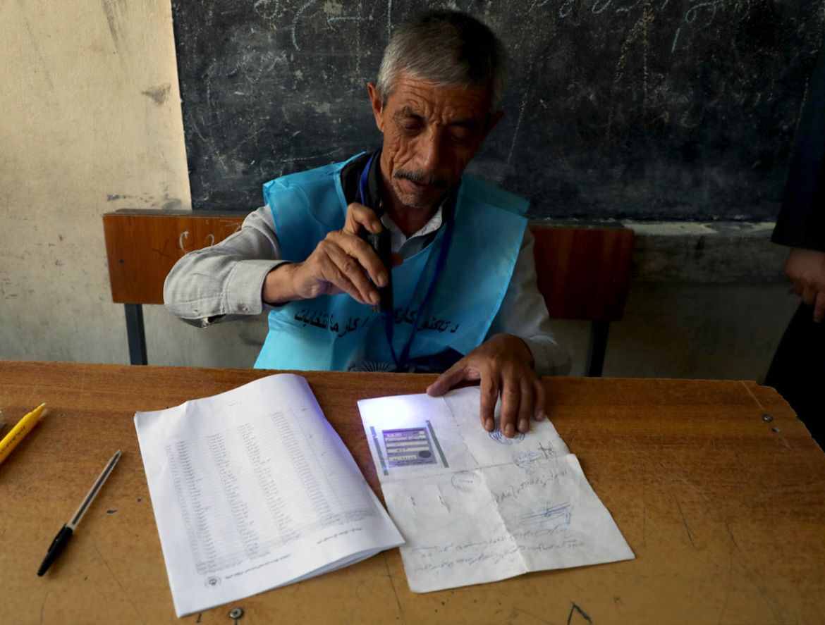 An election official checks voter''s documents with an UV flashlight at a polling station during a presidential election in Kabul, Afghanistan September 28, 2019. REUTERS/Omar Sobhani