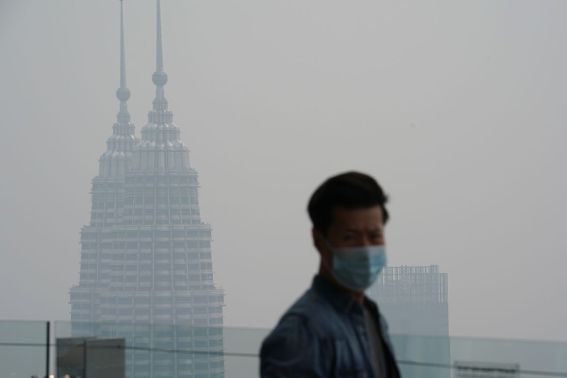 A tourist watches at Kuala Lumpur Tower as city stands shrouded with haze in Kuala Lumpur, Malaysia, Wednesday, Sept. 18, 2019. Indonesian forest fires spread health-damaging haze across the country a
