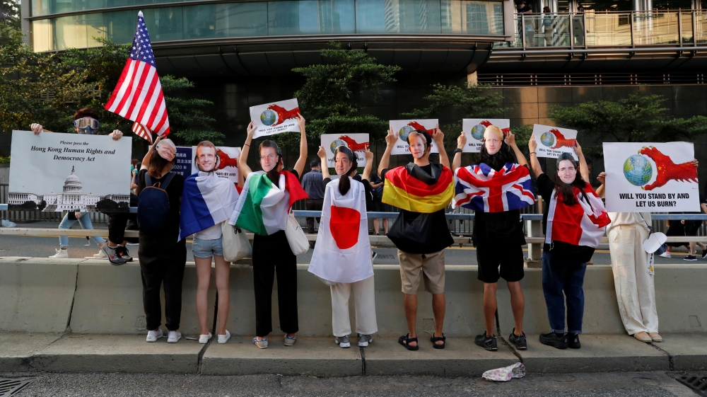 Protesters wear masks of the G7 leaders during a rally to the U.S. Consulate General in Hong Kong