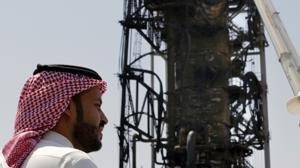 n this photo opportunity during a trip organized by Saudi information ministry, a man watches the damaged in the Aramco's Khurais oil field, Saudi Arabia, Friday, Sept. 20, 2019