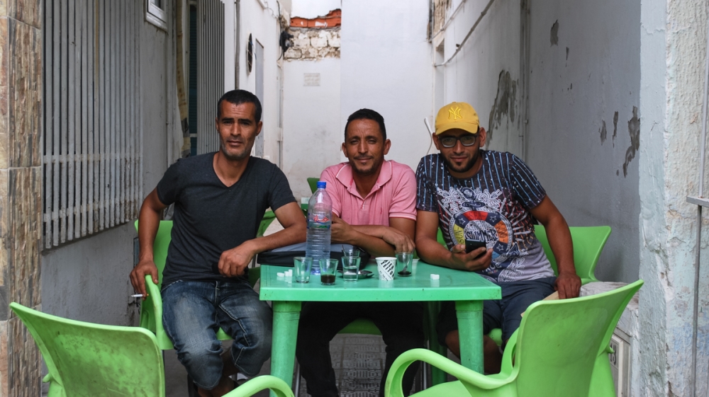 Three men sat at Cafe Samarkand in Sidi Bouzid, including Nacer Gharbi (farmer cited in the piece). Other two are his relatives. [Layli Foroudi/Al Jazeera]
