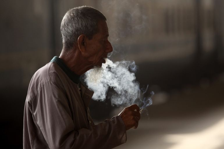 A man smokes a cigarette as he waits for a train at the platform of the central railway station in Dhaka, Bangladesh, 09 December 2013
