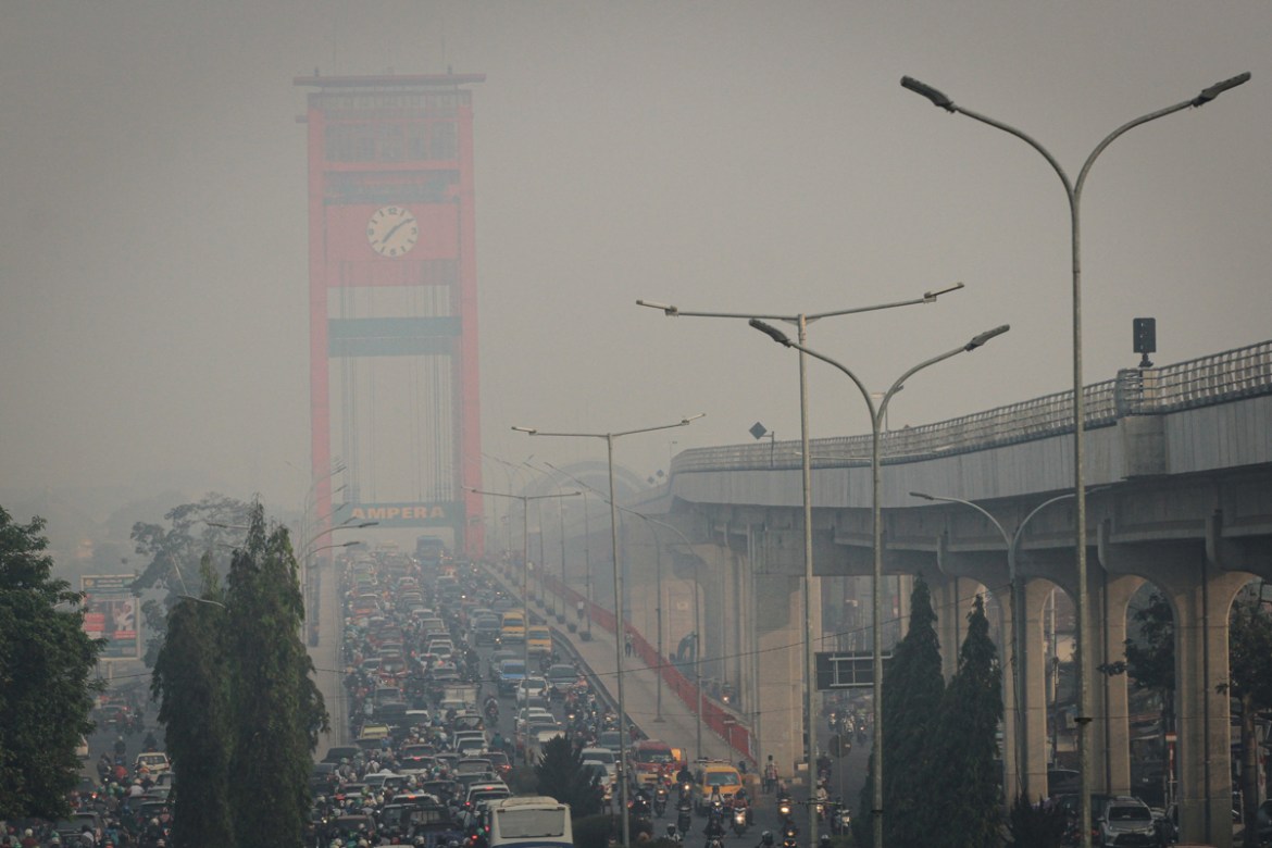 Motorists commute on a hazy day in Palembang on September 18, 2019. - Indonesia has arrested nearly 200 people over vast forest fires ripping across the archipelago, police said as toxic haze sends ai