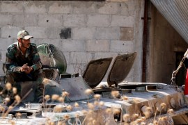 A Syrian army soldier smokes cigarette as he sits on a military vehicle in Khan Sheikhoun, Idlib