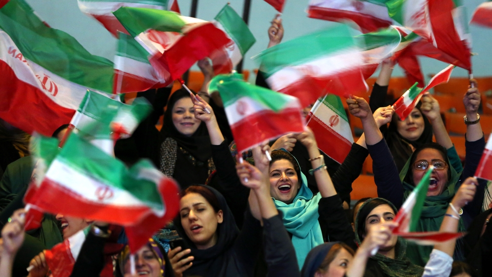Iranian women wave Iranian flags during a ceremony of farewell for their national soccer team ahead of the 2014 World Cup in Brazil, at the hall of Azadi (freedom) sports compound in Tehran, Iran, Mon