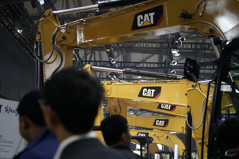People visit heavy machinery of Caterpillar at Bauma China, the International Trade Fair for Construction Machinery in Shanghai, China