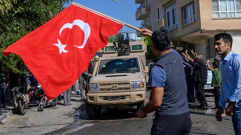 A man waves a Turkish flag as Turkey-backed Syrian opposition fighters going to Tel Abyad from Turkish gate towards Syria in Akcakale in Sanliurfa province on October 10, 2019. Turkey has launched a b