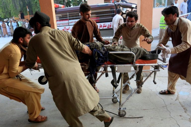 Men carry an injured person to a hospital after a blast in Jalalabad, Afghanistan