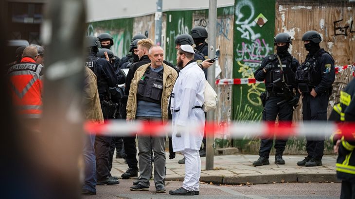 Rescued parishioners of the Jewish community and police forces stand near the scene of a shooting that has left two people dead on October 9, 2019 in Halle, Germany. (Photo by Jens Schlueter/Getty Im
