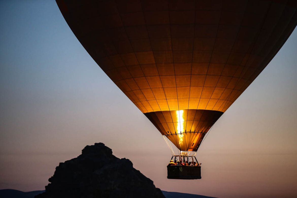 A hot air balloon, carrying tourists, rises into the sky at sunrise in Cappadocia, central Turkey, early Tuesday, Aug. 7, 2018. Cappadocia has become a favourite site for tourists in hot-air balloons
