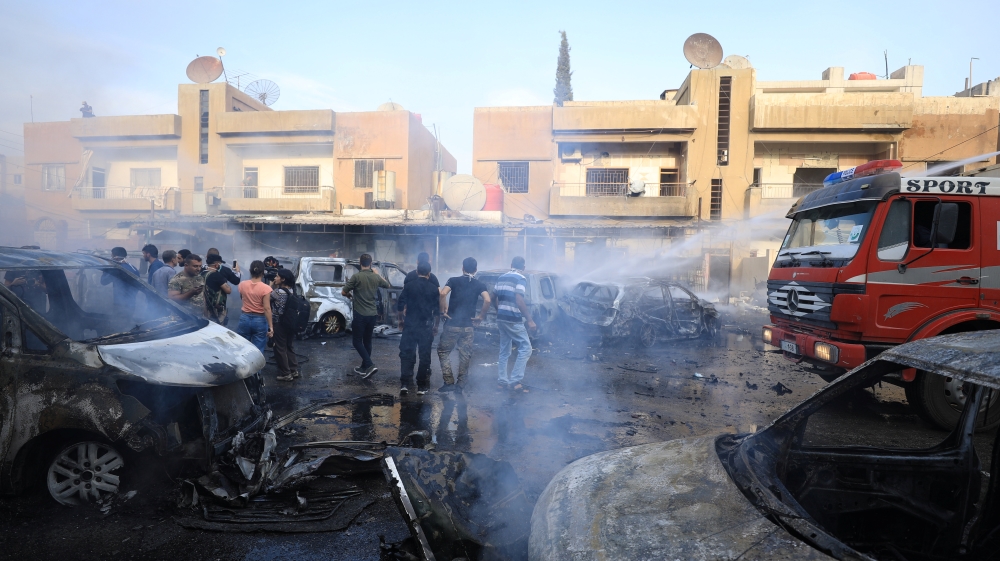 People gather at the site of a car bomb blast in Qamishli