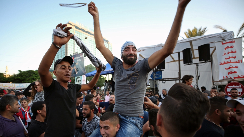 Protestors celebrate after the Prime Minister Saad al-Hariri announced his resignation, in Sidon