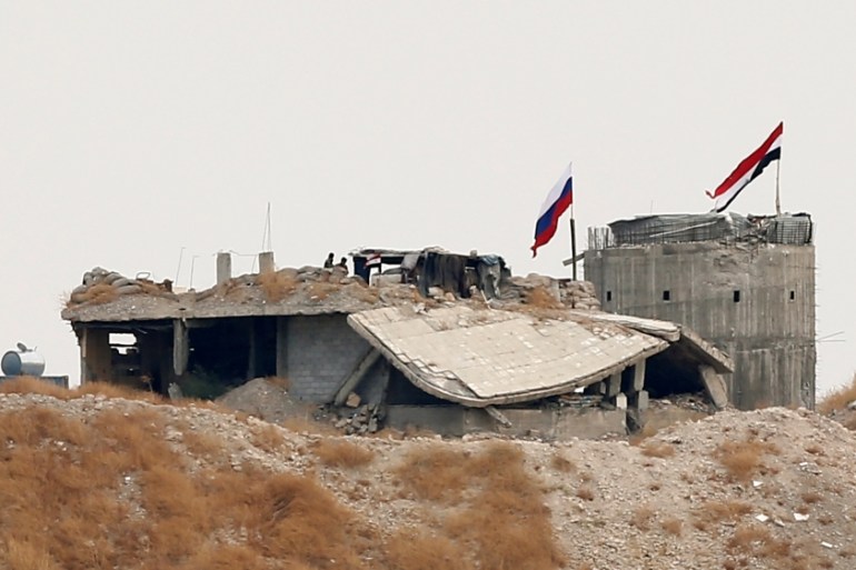 Russian and Syrian national flags are pictured near the northern Syrian village of Zor Magar, as seen from the Turkish border town of Karkamis