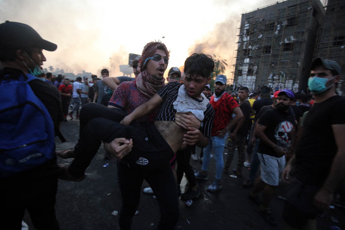 An Iraqi protester carries a wounded comrade during a demonstration against state corruption, failing public services and unemployment at Tayaran square in Baghdad on October 2, 2019. Iraq''s president