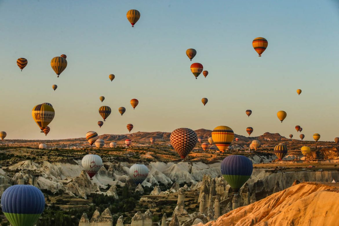 Hot air balloons, carrying tourists, rise into the sky at sunrise in Cappadocia, central Turkey, early Tuesday, Aug. 7, 2018. Cappadocia has become a favourite site for tourists in hot-air balloons wh