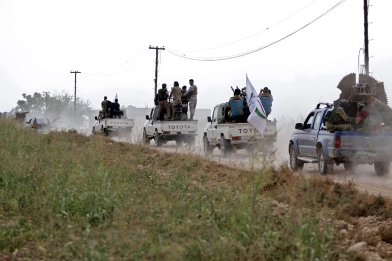 A convoy of pickup trucks transports Turkey-backed Syrian fighters on the road between the Syrian towns of Tal Abyad and Kobani on the Turkish border on October 16, 2019