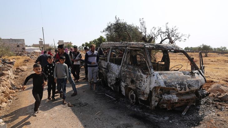 People look at a destroyed van near the village of Barisha, in Idlib province, Syria, Sunday, Oct. 27, 2019, after an operation by the U.S. military which targeted Abu Bakr al-Baghdadi, the shadowy le