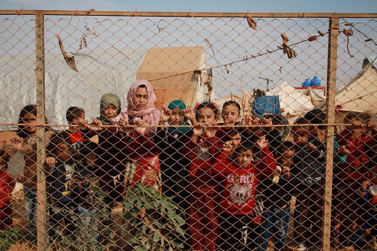 Displaced Syrian children stand behind a fence outside their tents a camp set up near the village of Kafr Lusin, in Idlib''s northern countryside near the Syria-Turkey border, on October 22, 2019. - Th