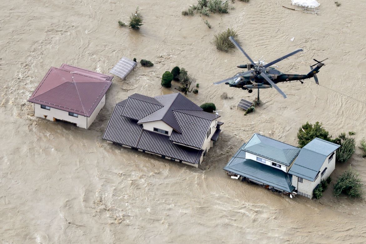 An aerial view shows a Japan Self-Defence Force helicopter flying over residential areas flooded by the Chikuma river following Typhoon Hagibis in Nagano, central Japan, October 13, 2019, in this phot