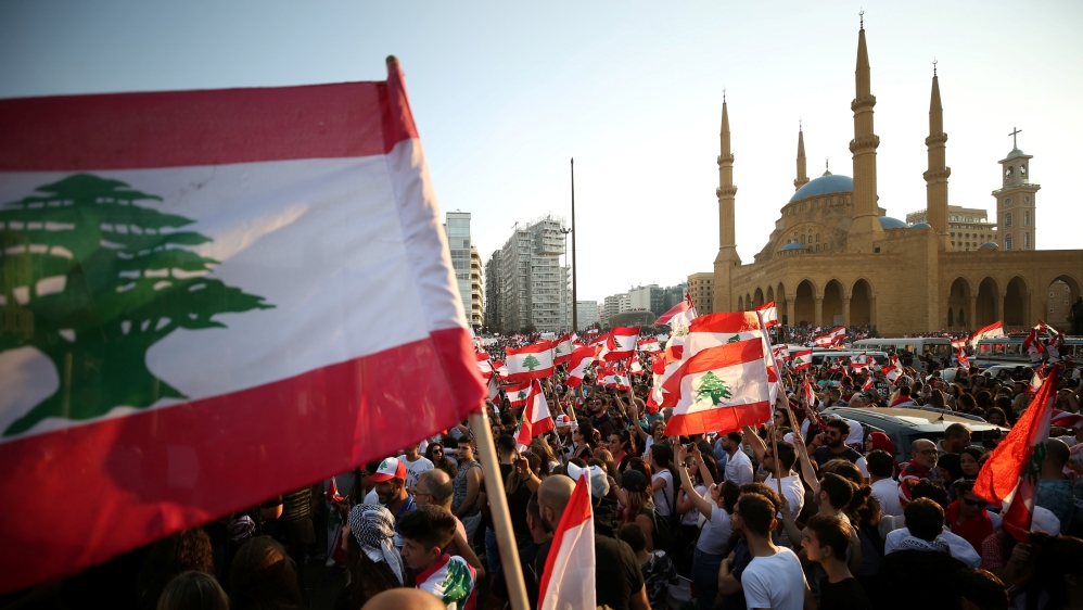Demonstrators carry national flags during an anti-government protest near Al-Amin mosque in downtown Beirut, Lebanon October 20, 2019. 