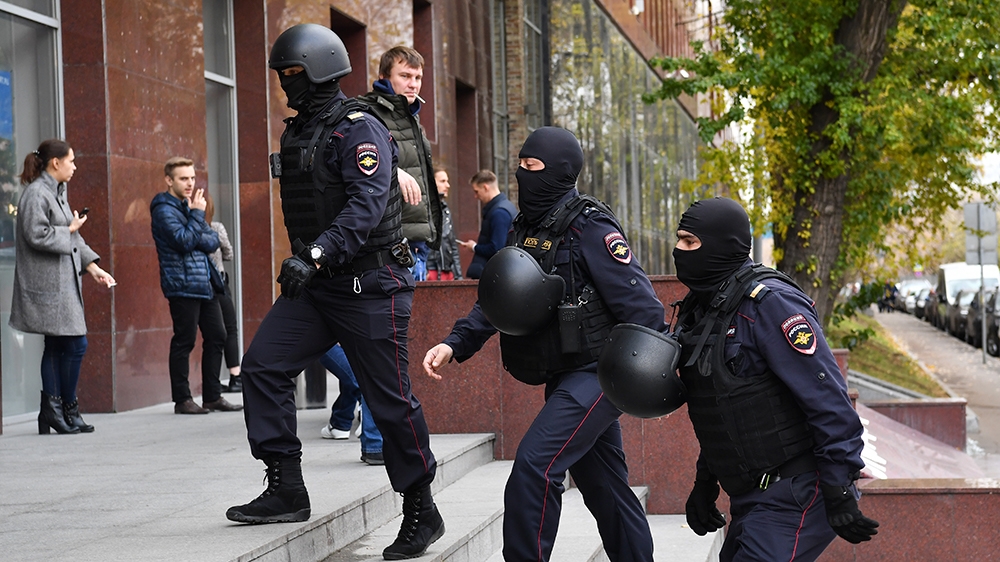 Russian police officers walk to enter a business centre, which houses the office of opposition leader Alexei Navalny's Anti-Corruption Foundation (FBK), in Moscow on October 15, 2019. - Russian invest