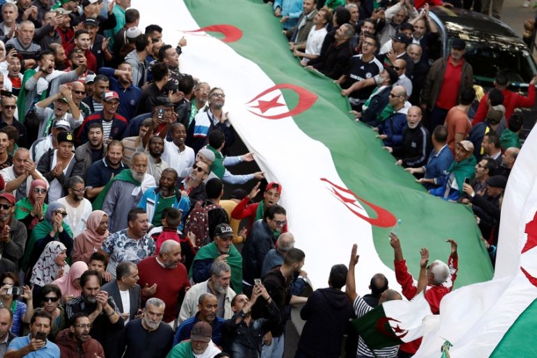 Demonstrators carry national flags during a protest in Algiers
