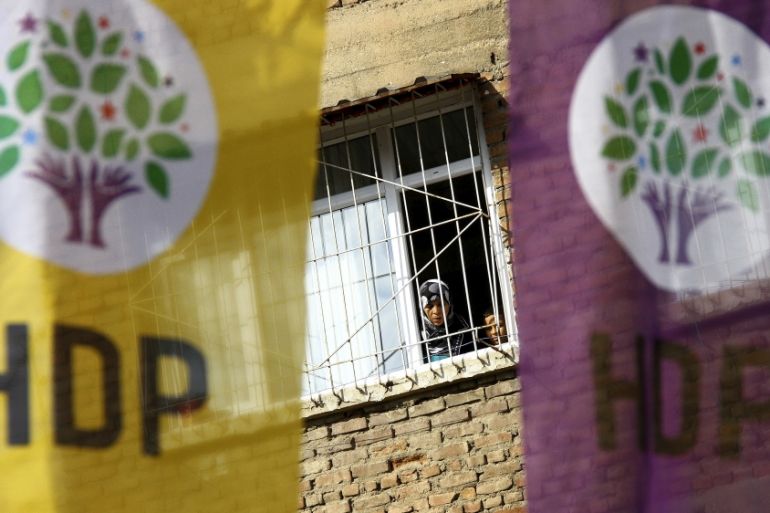 Woman and a boy look out of a balcony as election banners of the pro-Kurdish Peoples'' Democratic Party (HDP) hang outside in Diyarbakir
