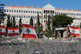 National flags are seen on a razor wire near the government palace in Beirut