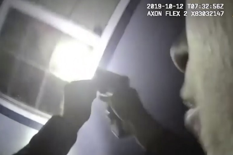 In this Saturday, Oct. 12, 2019, image made from a body camera video released by the Fort Worth Police Department an officer shines a flashlight into a window in Fort Worth, Texas. A black woman was f