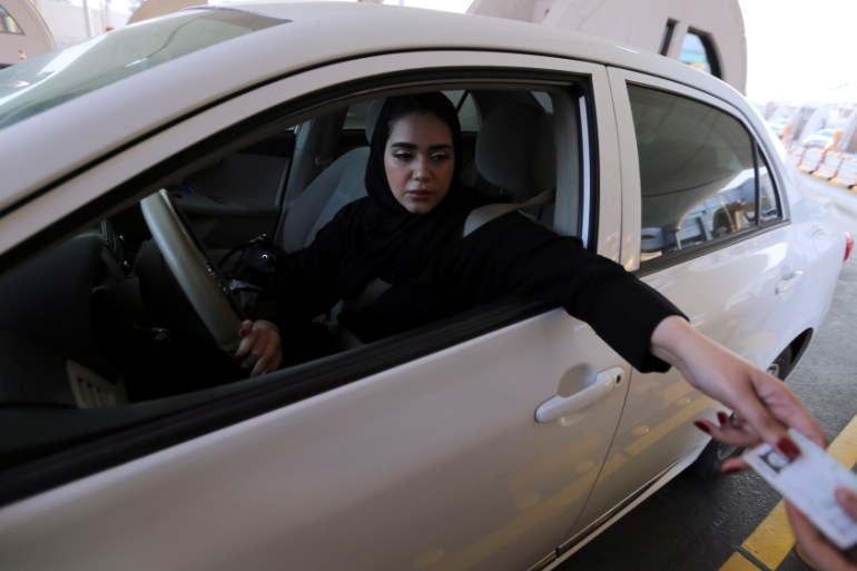 Saudi woman shows her national ID card at the Bahrain immigration checkpoint, as she drives to Bahrain on the King Fahd Causeway