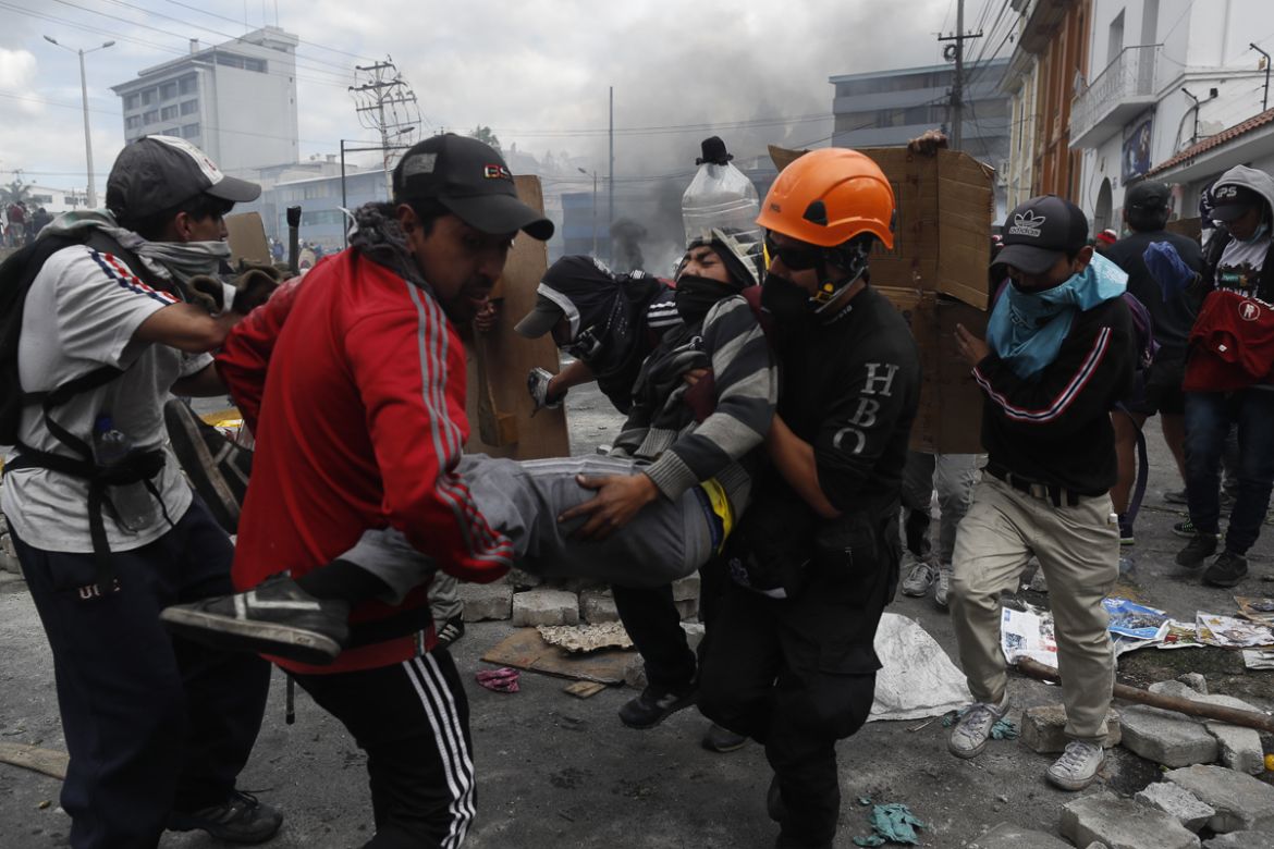 Protesters help a man during clashes with the police on the tenth day of protests against the government, in Quito, Ecuador, 12 October 2019. The wave of protests in Ecuador, led by the indigenous mov