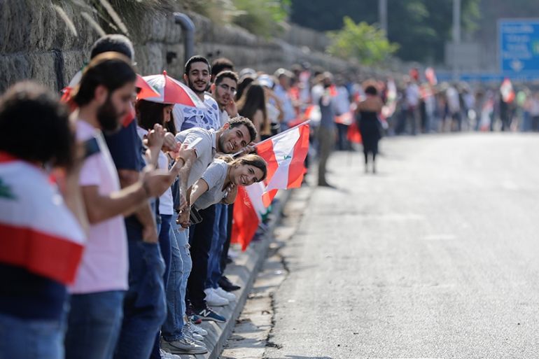 Lebanese protesters hold hands to form a human chain along the coast from north to south as a symbol of unity, during ongoing anti-government demonstrations in Nahr al-Kalb north of Lebanon''s capital