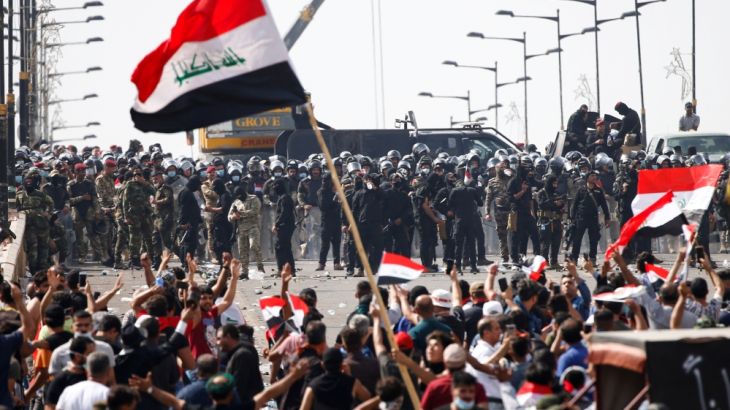 Iraqi security forces stand in front of demonstrators during a protest over corruption, lack of jobs, and poor services, in Baghdad, Iraq October 25, 2019