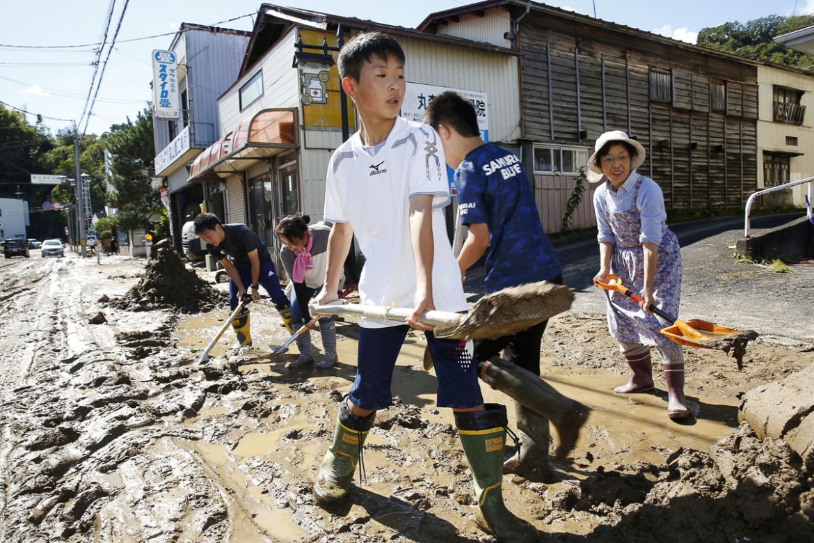 Schoolchildren and residents remove mud after flooding caused by Typhoon Hagibis in Marumori, Miyagi prefecture, Japan, October 13, 2019, in this photo taken by Kyodo. Mandatory credit Kyodo/via REUTE