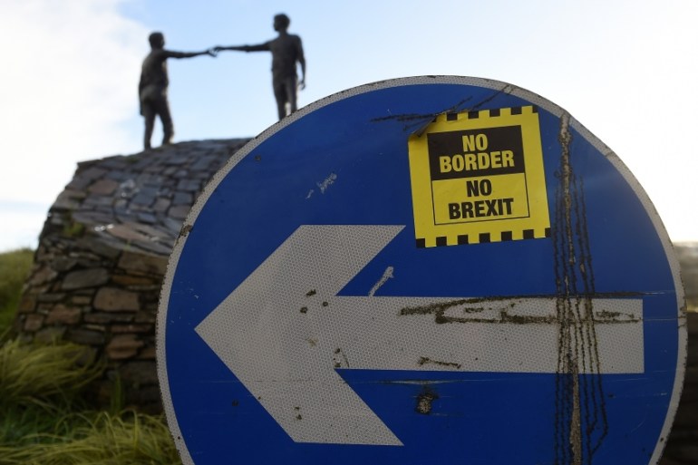 A '' No Border, No Brexit'' sticker is seen on a road sign in front of the Peace statue entitled ''Hands Across the Divide'' in Londonderry, Northern Ireland, January 22, 2019