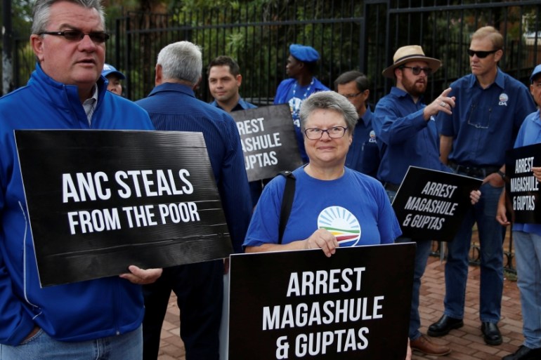 Protesters hold placards outside the Bloemfontein Regional Court