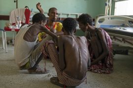 In this Aug. 1, 2019 photo, Ethiopian migrants, from center background to right, Gamal Hassan, Abdu Yassin, Mohammed Hussein, and Abdu Mohammed, who were imprisoned by traffickers for months, eat rice