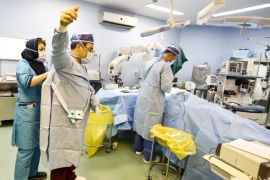 Iranian surgeon Ali Manafi puts on his sterile