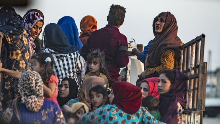 Syrian Arab and Kurdish civilians flee amid Turkish bombardment on Syria''s northeastern town of Ras al-Ain in the Hasakeh province along the Turkish border. [Delil Souleiman/AFP]