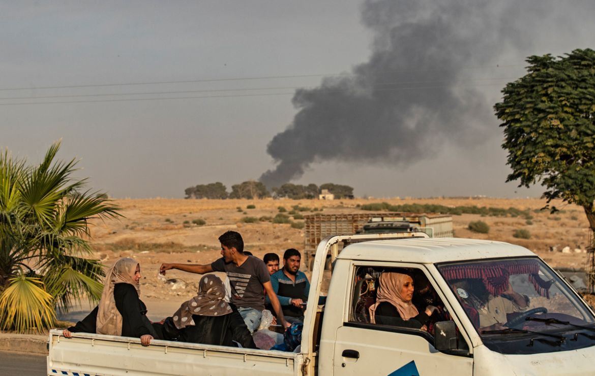 Civilians ride a pickup truck as smoke billows following Turkish bombardment on Syria''s northeastern town of Ras al-Ain in the Hasakeh province along the Turkish border on October 9, 2019. - Turkey la