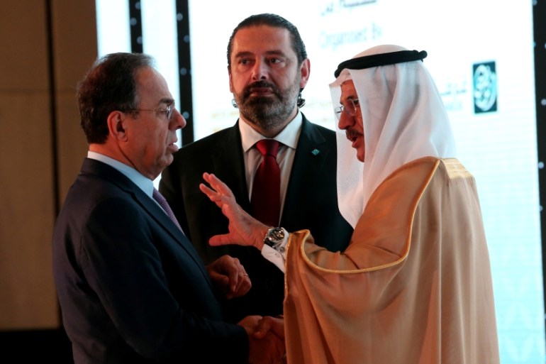 Lebanese Prime Minister Saad Hariri is seen as his advisor Nadim Al Mulla speaks with Sultan Bin Saeed Al Mansoori, UAE''s economy minister, at the UAE-Lebanon Investment Forum in Abu Dhabi