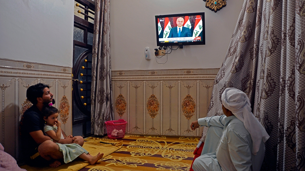Iraqis watch a televised speech by Iraq's President Barham Saleh in the central holy shrine city of Najaf on October 31, 2019. - Saleh vowed to hold early parliamentary elections once a new law is pas