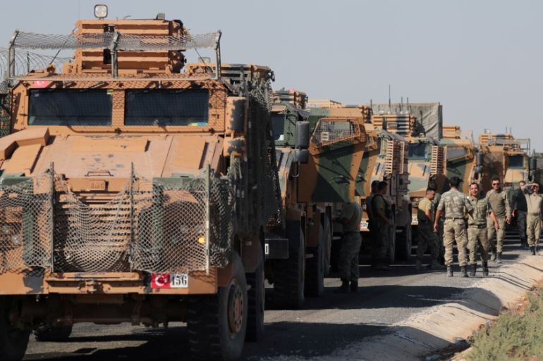 Turkish soldiers stand near military trucks in the village of Yabisa, near the Turkish-Syrian border, Syria, October 12, 2019
