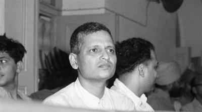 Nathuram Godse, à esquerda, um dos nove co-réus no caso de conspiração para o assassinato de Mohandas Gandhi, e o conselheiro de defesa LB Bhopatkar conferem em 27 de maio de 1948, no início da audiência.  (foto AP)