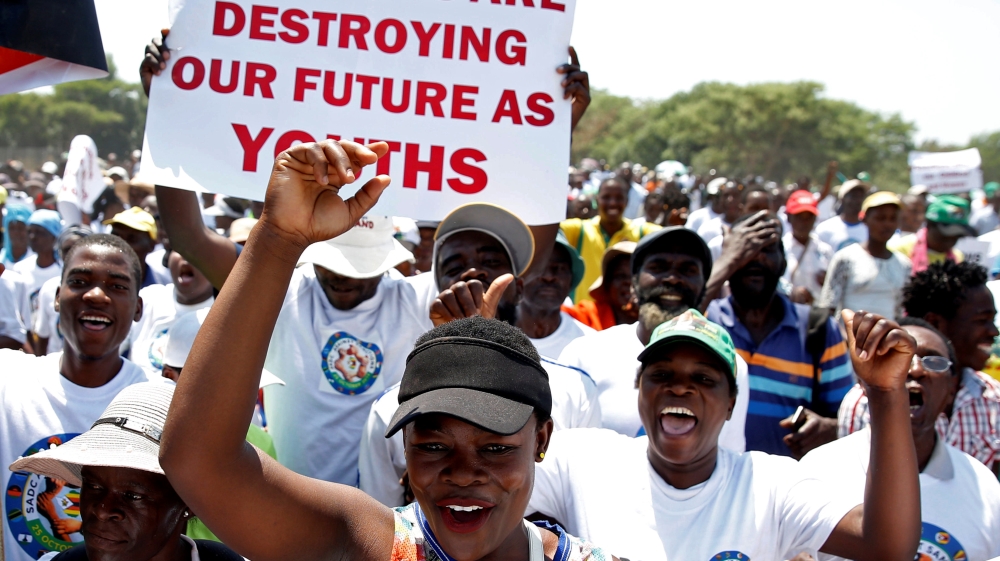 Government supporters chant slogans as they march against Western sanctions at a rally in Harare