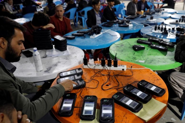 Afghan election commission workers transfer data from biometric devices to the main server at a warehouse in Kabul