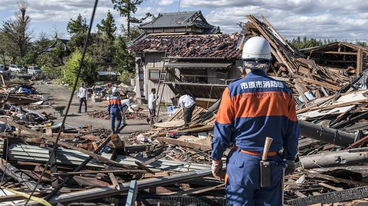 Search and rescue crews sort through the debris of a building destroyed by a tornado shortly before the arrival of Typhoon Hagibis, on October 13, 2019 in Chiba, Japan. At least five people are report