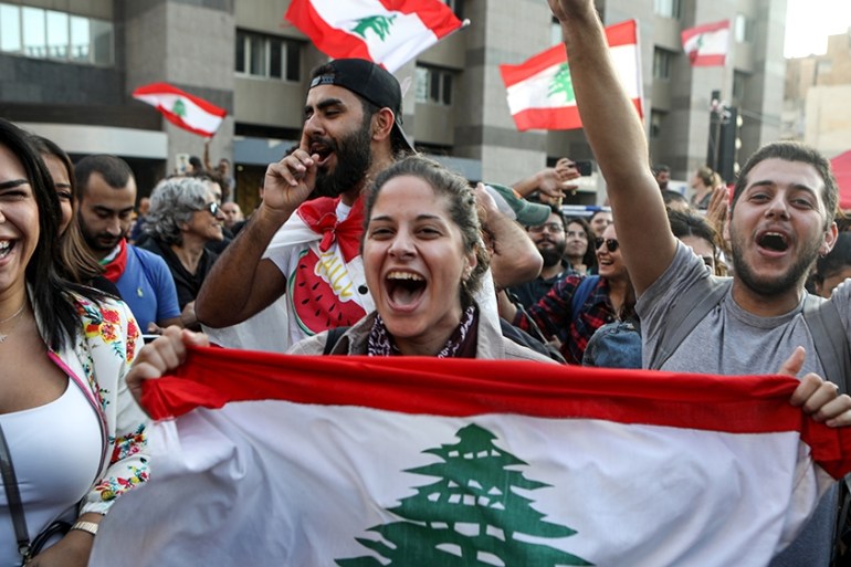 Lebanese anti-government protesters celebrate the resignation of Prime Minister Saad Hariri in Beirut on October 29, 2019 on the 13th day of anti-government protests. (Photo by Patrick BAZ / AFP)